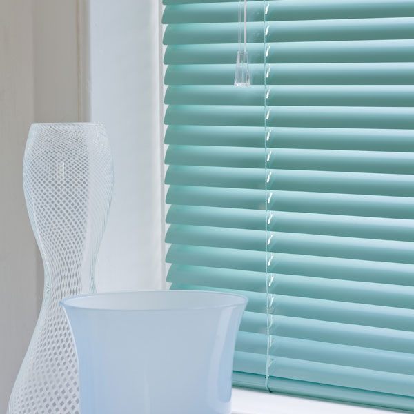 Metal venetian blinds with tilted slats controlling the light